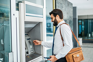 Customer using an ATM supplied and serviced by one of the best ATM vendors in NJ