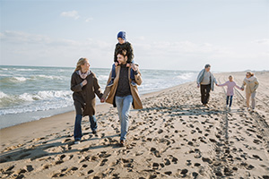 Family walking along beach in winter while staying at a Seaside Park rental