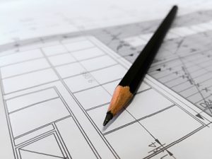 Builders in Ocean County plans with pencil and square