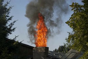 Fire shooting out of a chimney from a build-up of creosote - Call a manasquan chimney service pro today to protect your home